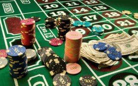 Close-up of live roulette wheel with betting chips on green felt table